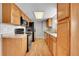 Bright kitchen with stainless steel appliances, wood cabinets, and durable laminate floors at 8595 Field Ct, Arvada, CO 80005