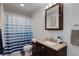 This bathroom features a vanity with granite countertop, a shower with a striped blue shower curtain, and stylish fixtures at 11081 Cannonade Dr, Parker, CO 80138