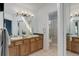Well-lit bathroom with double sinks, oak cabinets, and a separate shower, offering convenience and style at 11081 Cannonade Dr, Parker, CO 80138