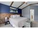 Comfortable main bedroom with an artistic blue accent wall, wooden headboard, and plenty of natural light at 11081 Cannonade Dr, Parker, CO 80138