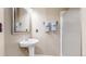 Modern bathroom featuring a sleek pedestal sink, a framed mirror, and a walk-in shower at 10517 Clermont Way, Thornton, CO 80233