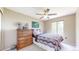 Bedroom with a ceiling fan, large wooden dresser, and window providing natural light at 10517 Clermont Way, Thornton, CO 80233
