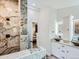 Bathroom with marble shower, dual vessel sinks, backlit mirrors, and cabinet storage at 629 Copperdale Ln, Golden, CO 80401
