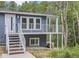 Blue home with white railing, stairs to porch, and windowed door surrounded by trees at 629 Copperdale Ln, Golden, CO 80401