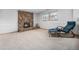 Carpeted basement area featuring a stone fireplace with hearth and a chair with ottoman at 10473 W Arkansas Dr, Lakewood, CO 80232