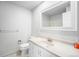 Clean bathroom featuring a white vanity, toilet, and large mirror at 10473 W Arkansas Dr, Lakewood, CO 80232