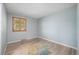 Cozy bedroom featuring a modern light fixture, wood floors, large window, and a vibrant area rug at 10473 W Arkansas Dr, Lakewood, CO 80232