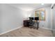 Bright bedroom featuring hardwood floors, desk with computer, and natural light from the window at 10473 W Arkansas Dr, Lakewood, CO 80232