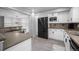 Modern kitchen with white cabinetry, a black refrigerator, and stainless steel accents at 10473 W Arkansas Dr, Lakewood, CO 80232