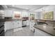 Bright kitchen featuring white cabinets, stainless steel appliances, and wood flooring at 10473 W Arkansas Dr, Lakewood, CO 80232
