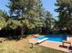 This in-ground pool features mature trees, a diving board and seating at 10473 W Arkansas Dr, Lakewood, CO 80232