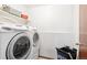 Laundry area featuring a washer, dryer, shelves, and a laundry basket at 9036 W Wisconsin Ave, Lakewood, CO 80232