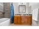 Bathroom featuring double vanity, wooden cabinets, and shower-tub combination at 9390 W Chatfield Pl # 108, Littleton, CO 80128