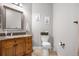 Charming bathroom featuring wood vanity, decorative mirror, and playful animal-themed wall art at 9390 W Chatfield Pl # 108, Littleton, CO 80128
