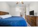 Comfortable bedroom with hardwood floors, TV, and en-suite bathroom at 9390 W Chatfield Pl # 108, Littleton, CO 80128