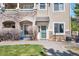 Inviting condo exterior with stone accents, manicured lawn, and a welcoming green front door at 9390 W Chatfield Pl # 108, Littleton, CO 80128