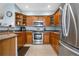 Kitchen with stainless steel appliances, wooden cabinets, and granite countertops at 9390 W Chatfield Pl # 108, Littleton, CO 80128