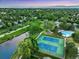 Aerial view of a neighborhood with a community pool, tennis courts, and a scenic lake at 8940 W 80Th Dr, Arvada, CO 80005