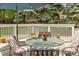 Back deck showing an outdoor seating area with a glass table, chairs, flowers and an umbrella at 8940 W 80Th Dr, Arvada, CO 80005