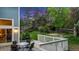 Spacious backyard with a wooden deck, lush lawn, mature trees, and a privacy fence at 8940 W 80Th Dr, Arvada, CO 80005