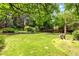 Large, lush backyard featuring a grassy lawn, mature trees, and a wooden fence for privacy at 8940 W 80Th Dr, Arvada, CO 80005