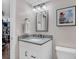 Modern bathroom featuring a vanity with gray countertop, framed mirror, and elegant lighting at 8940 W 80Th Dr, Arvada, CO 80005