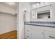 Bathroom features a gray vanity and a closet with wood floor at 8940 W 80Th Dr, Arvada, CO 80005