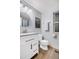 Updated bathroom with modern fixtures, a round mirror, and a vanity with plenty of storage at 8940 W 80Th Dr, Arvada, CO 80005