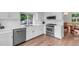 Bright kitchen with stainless steel appliances, white cabinets, and wood flooring at 8940 W 80Th Dr, Arvada, CO 80005
