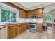 Functional kitchen with wooden cabinets, stainless steel appliances, and a bright window over the sink at 8940 W 80Th Dr, Arvada, CO 80005