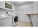 Clean laundry room with modern washer and dryer, shelving, and ample storage space at 8940 W 80Th Dr, Arvada, CO 80005