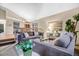 Cozy living room with plush gray sofas, stylish decor, and an open view to the dining area at 8940 W 80Th Dr, Arvada, CO 80005