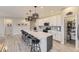 Open-concept kitchen with a large island, pendant lighting, white cabinets, and stainless steel appliances at 5775 Pinto Valley St, Parker, CO 80134