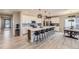Spacious kitchen featuring white cabinets, a large island with seating, and stainless steel appliances at 5775 Pinto Valley St, Parker, CO 80134