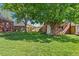 Well-maintained backyard with lush lawn, brick garage, mature trees, and wood fence at 1434 Clermont St, Denver, CO 80220