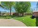 Lush backyard featuring brick garage, mature trees and an inviting brick patio at 1434 Clermont St, Denver, CO 80220