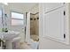 Bright bathroom with white cabinets, shower/tub with curtain, and decorative tile at 1434 Clermont St, Denver, CO 80220