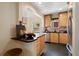 Kitchen with light wood cabinets, black countertops, stainless appliances, and eat-in bar at 1434 Clermont St, Denver, CO 80220