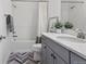 Beautiful bathroom with a shower-tub combo and a gray vanity with quartz countertop and herringbone tile floor at 14593 Tango Loop, Parker, CO 80134