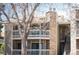 Exterior of the complex highlighting the stone chimney and private balconies at 8225 Fairmount Dr # 10-204, Denver, CO 80247
