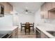 Modern kitchen with stainless steel appliances, marble countertops, light wood cabinets, and a dining area for four at 8225 Fairmount Dr # 10-204, Denver, CO 80247