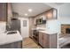 A modern kitchen features stainless steel appliances, light wood cabinets, and marble countertops with a fireplace visible at 8225 Fairmount Dr # 10-204, Denver, CO 80247