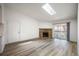 Sunlit living room featuring wood floors, a stone fireplace, and bright lighting at 8225 Fairmount Dr # 10-204, Denver, CO 80247