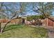 A backyard space, with lawn, trees and garden area, and brick home at 65 Reed St, Lakewood, CO 80226