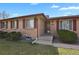 Welcoming entryway to a classic brick home with well-maintained landscaping at 65 Reed St, Lakewood, CO 80226