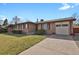Charming single-story brick home with an attached garage and mature landscaping at 65 Reed St, Lakewood, CO 80226