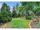 Beautiful backyard with mature trees, stone-lined flower beds, and verdant lawn, creating a peaceful outdoor retreat at 5190 W Mexico Ave, Denver, CO 80219