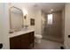 Bathroom featuring marble countertop, wood vanity, glass shower with mosaic tile, and stylish gold mirror at 2831 N Perry St, Denver, CO 80212