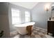 Stylish bathroom featuring a freestanding tub, checkered floor, and a dark wood vanity at 2831 N Perry St, Denver, CO 80212