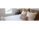 Bedroom showing neutral colors, many pillows and a bedside table with lamp and a window at 2831 N Perry St, Denver, CO 80212
